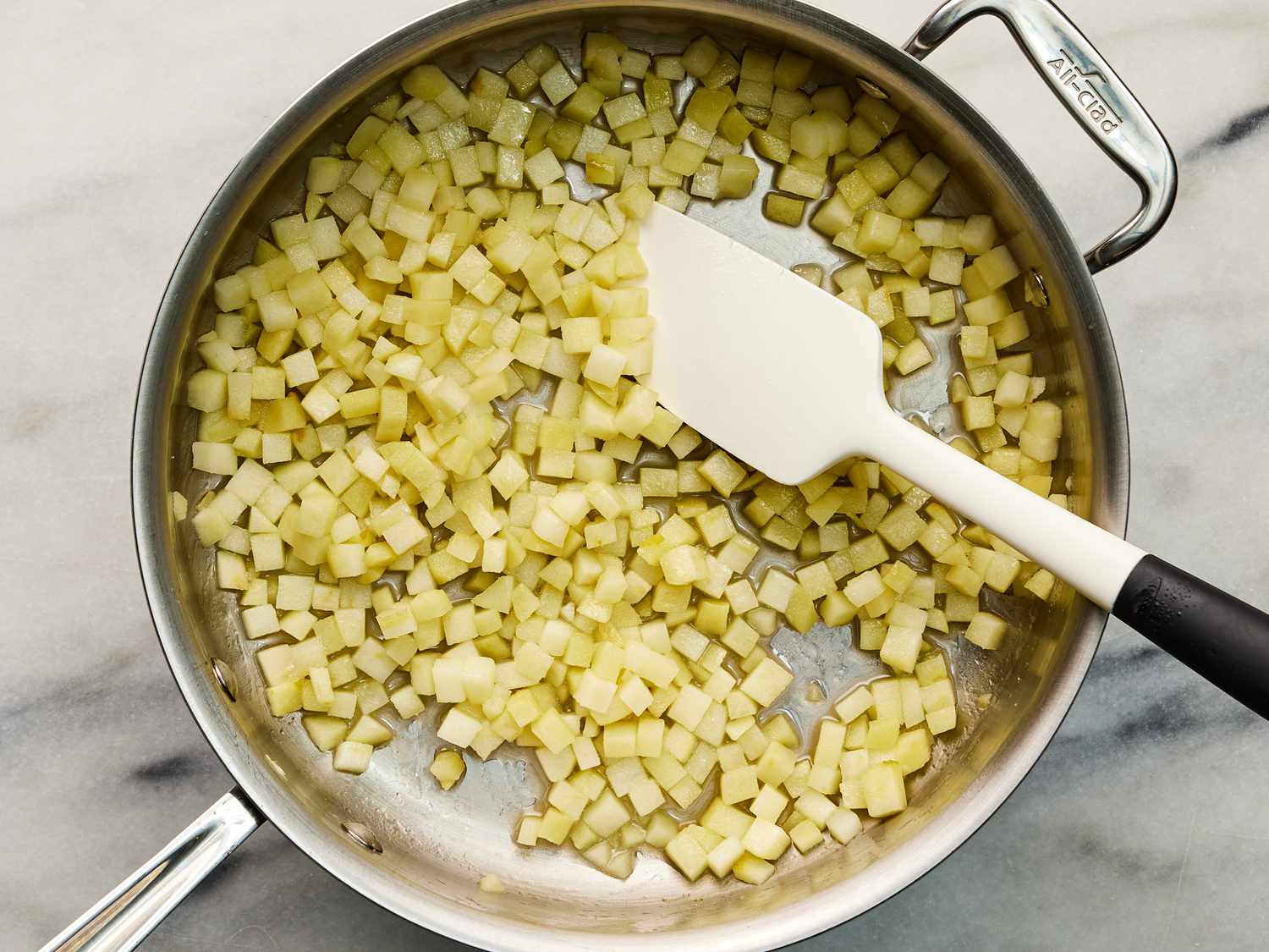 Diced apple and sugar mixture cooking in a skillet 