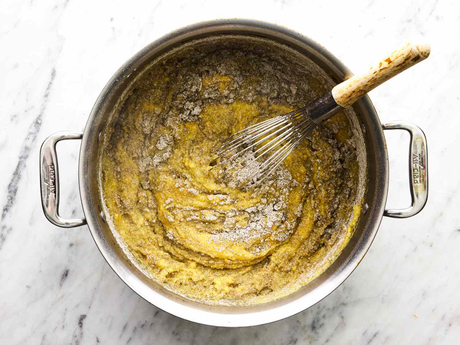 Overhead view of whisking cornmeal and pork stock together