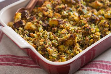 A red casserole dish of classic cornbread dressing made with oysters.