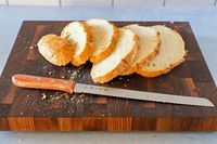 Tojiro F-737 Bread Slicer on cutting board next to sliced bread