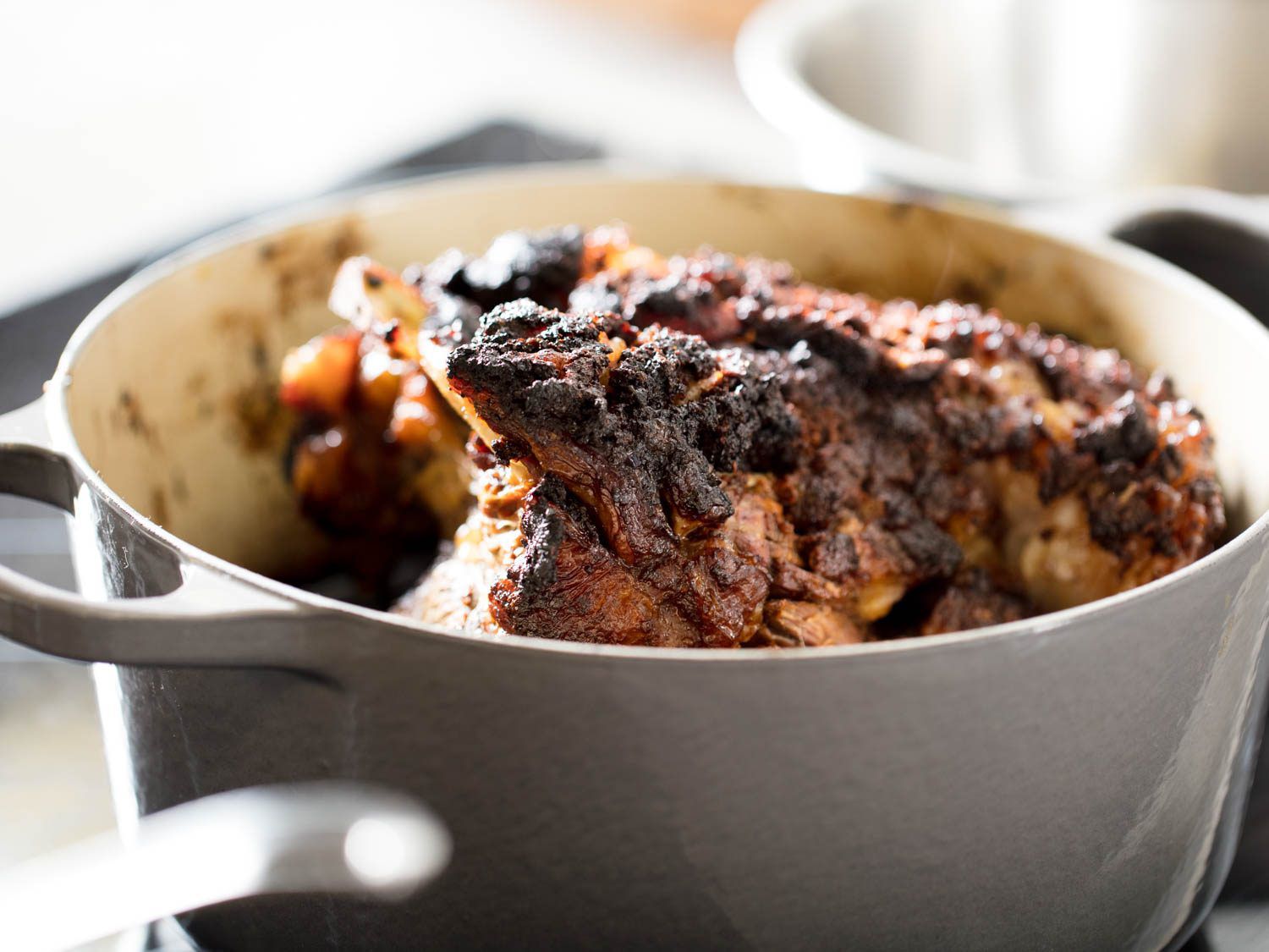 Braised chili-rubbed lamb shoulder in a Dutch oven