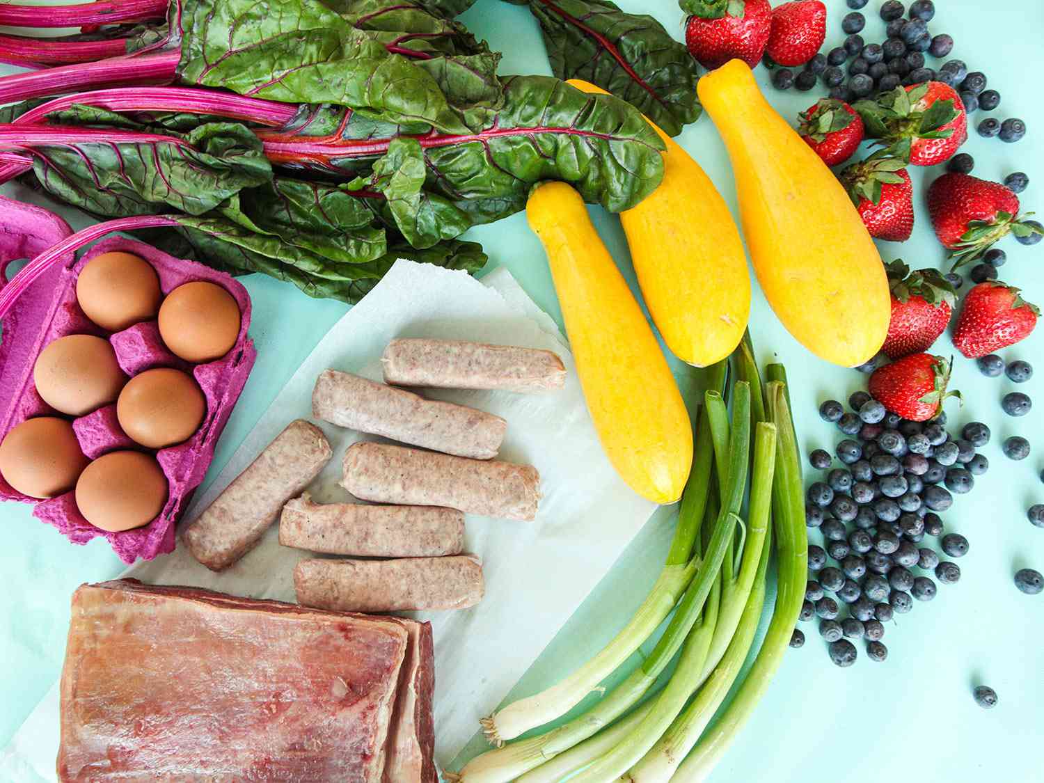 The Essentials Bundle CSA box from Local Roots CSA: eggs, sausages, scallions, squash, berries, and swiss chard