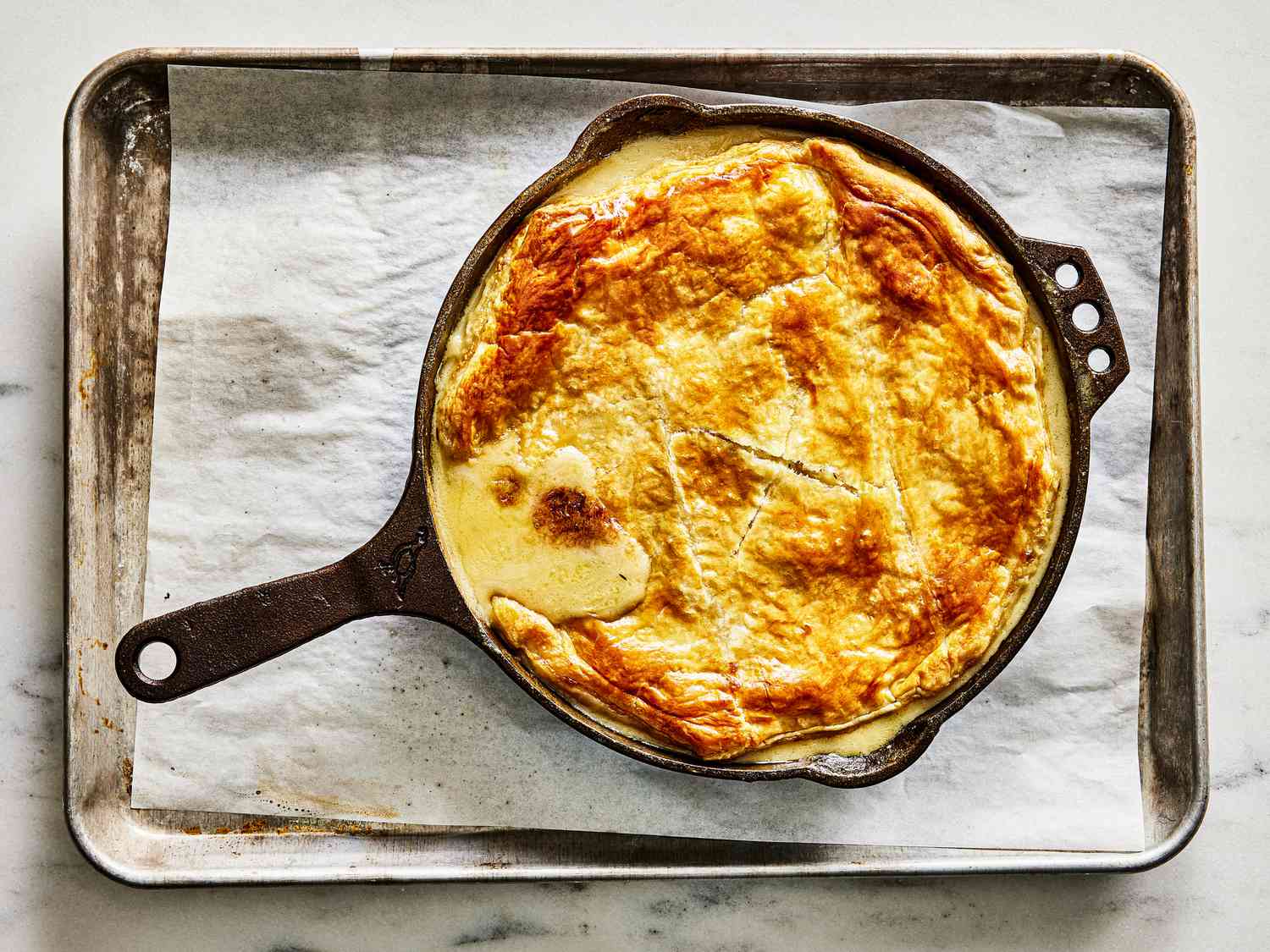 Baked Pot pie in skillet cooling on a sheet pan 