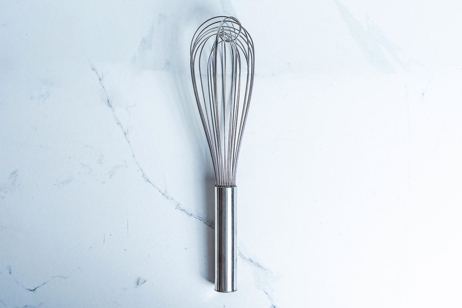 Winco Stainless Steel Piano Wire Whip on a marbled surface