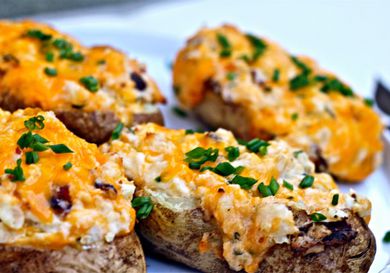 Close up of grilled, loaded twice-baked potatoes, ready to serve.