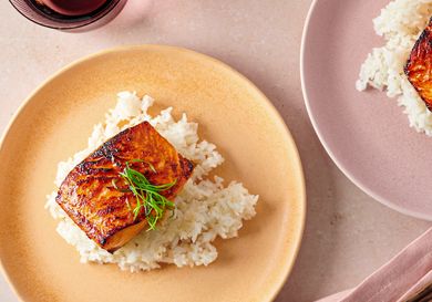 Miso glazed salmon served over white rice on a plate