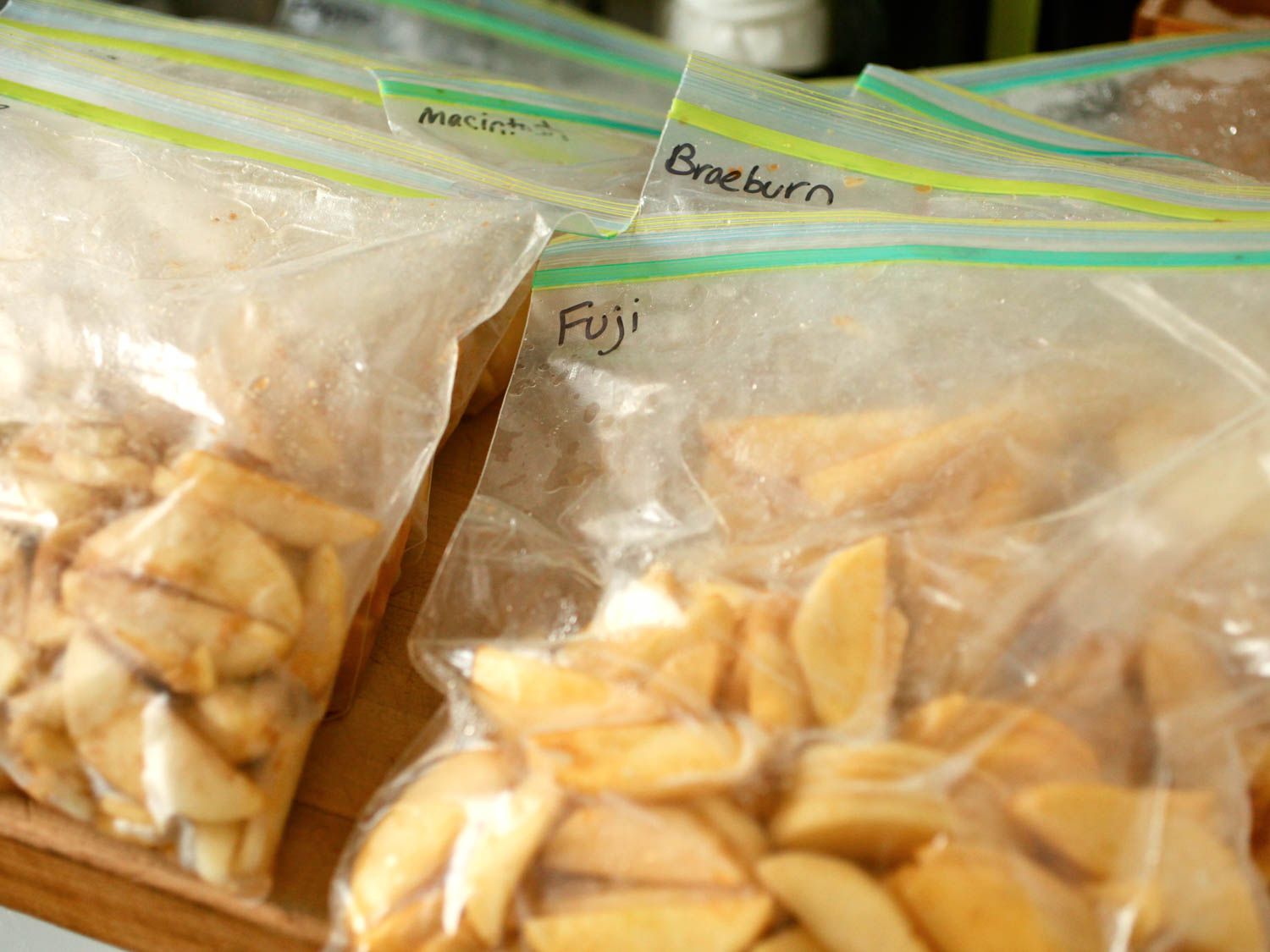 Various plastic bags filled with apple slices and labeled with their respective apple varieties