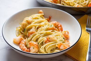 A bowl of shrimp scampi with pasta. 