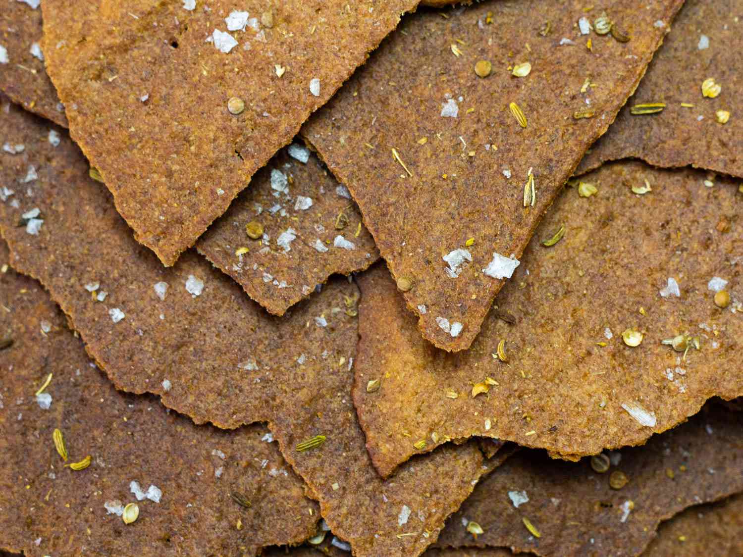 Shingled pieces of sourdough rye crackers sprinkled with flaky salt, coriander, and fennel seeds.
