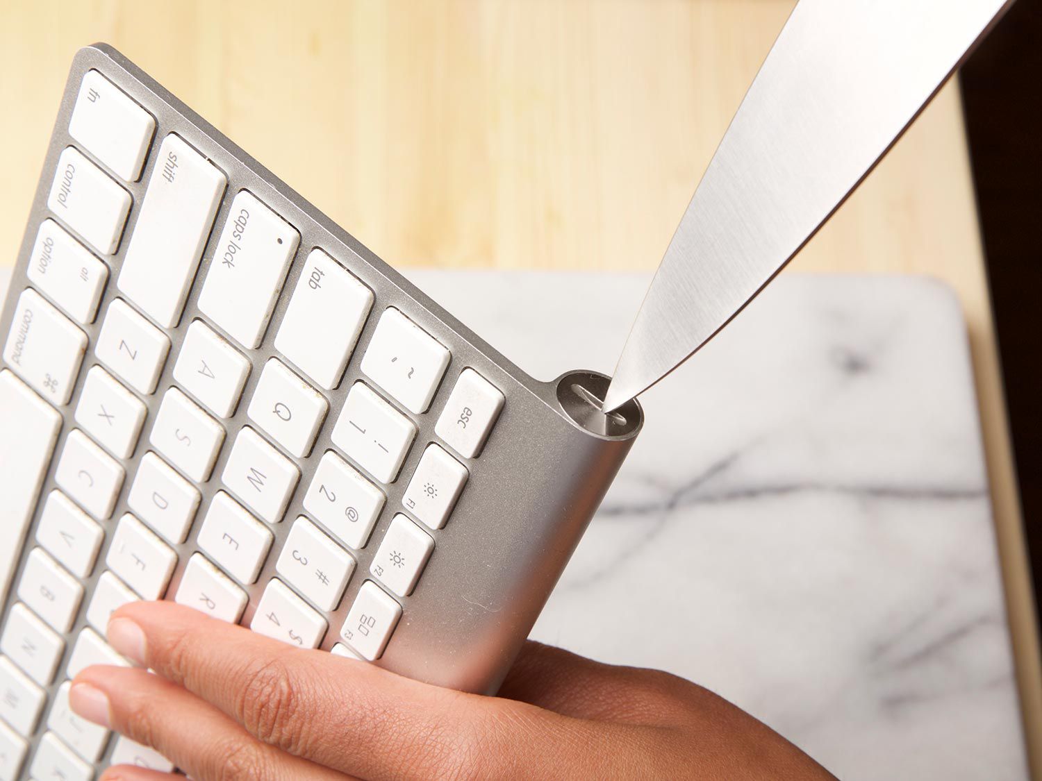 using a chef's to unscrew the side of a keyboard
