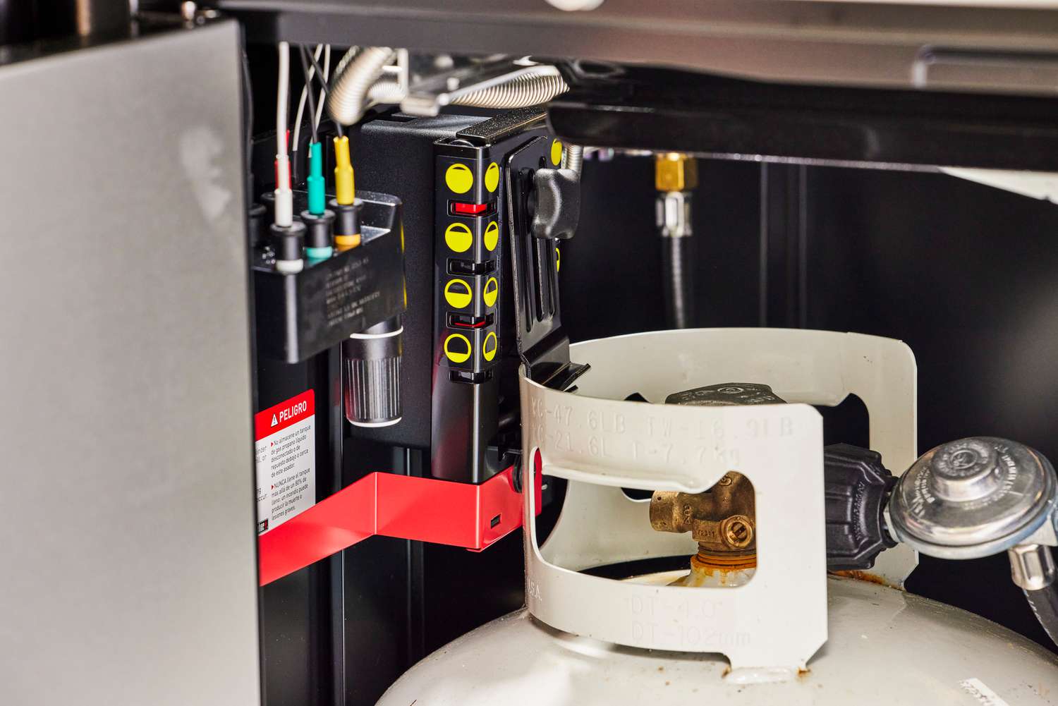 The propane tank hooked up inside the Weber Genesis E-335 Gas Grill