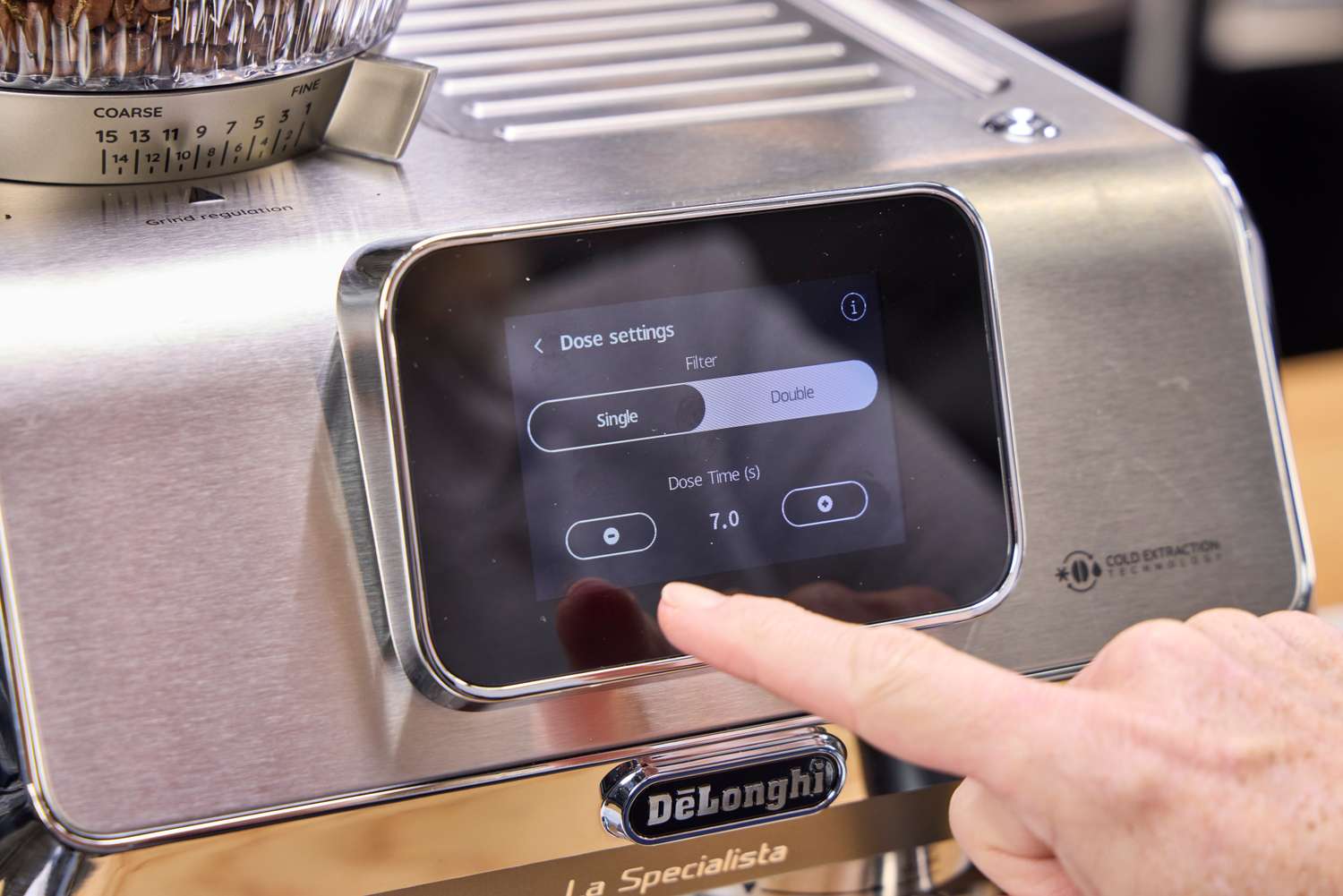 A person presses a button on the De'Longhi La Specialista Touch Espresso Machine