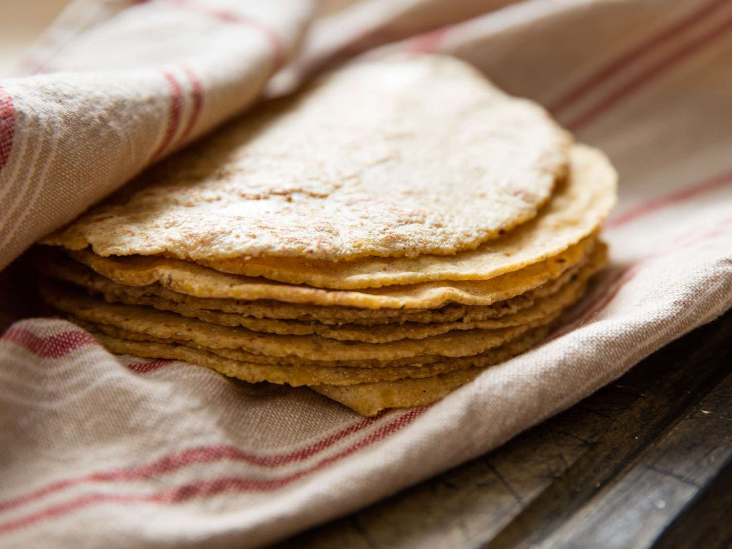 A stack of tortillas on a tea towel. 