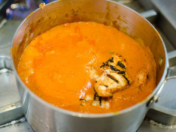 Adding grilled chicken tikka to butter chicken sauce
