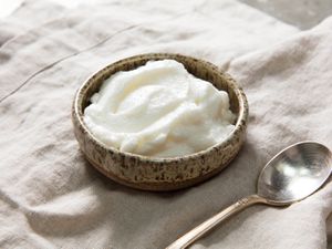 A small bowl of toum, Lebanese garlic sauce, with a spoon next to it.