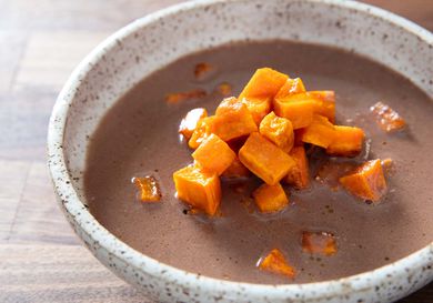 A bowl of Cherokee puréed nut soup topped with sweet potato.