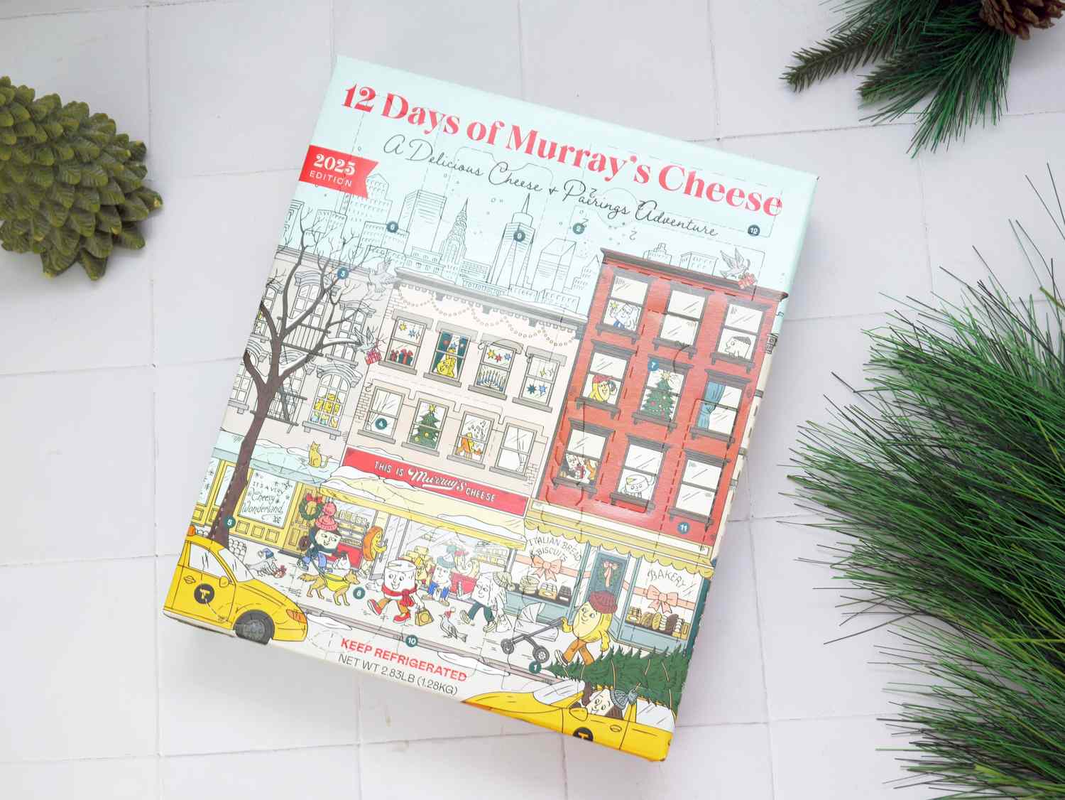 12 days of murrays cheese box on a white tile surface with greenery