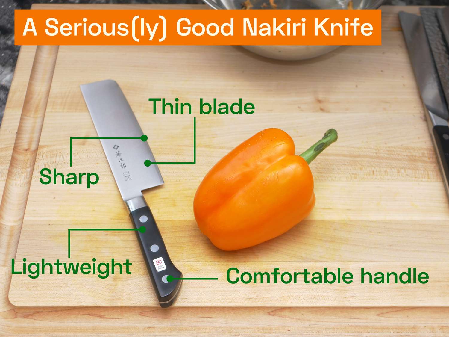 the tojiro nakiri on a wooden cutting board with an orange bell pepper