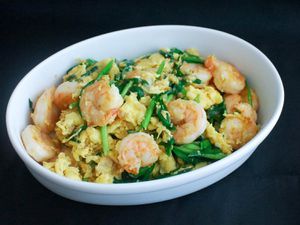 Stir-fried shrimp with eggs and Chinese chives, served in a white obblong serving bowl.