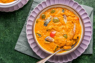 A bowl of Nigerian egg sauce served on a green placemat with a spoon