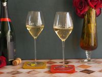 two glas vin tulip glasses filled with champagne.