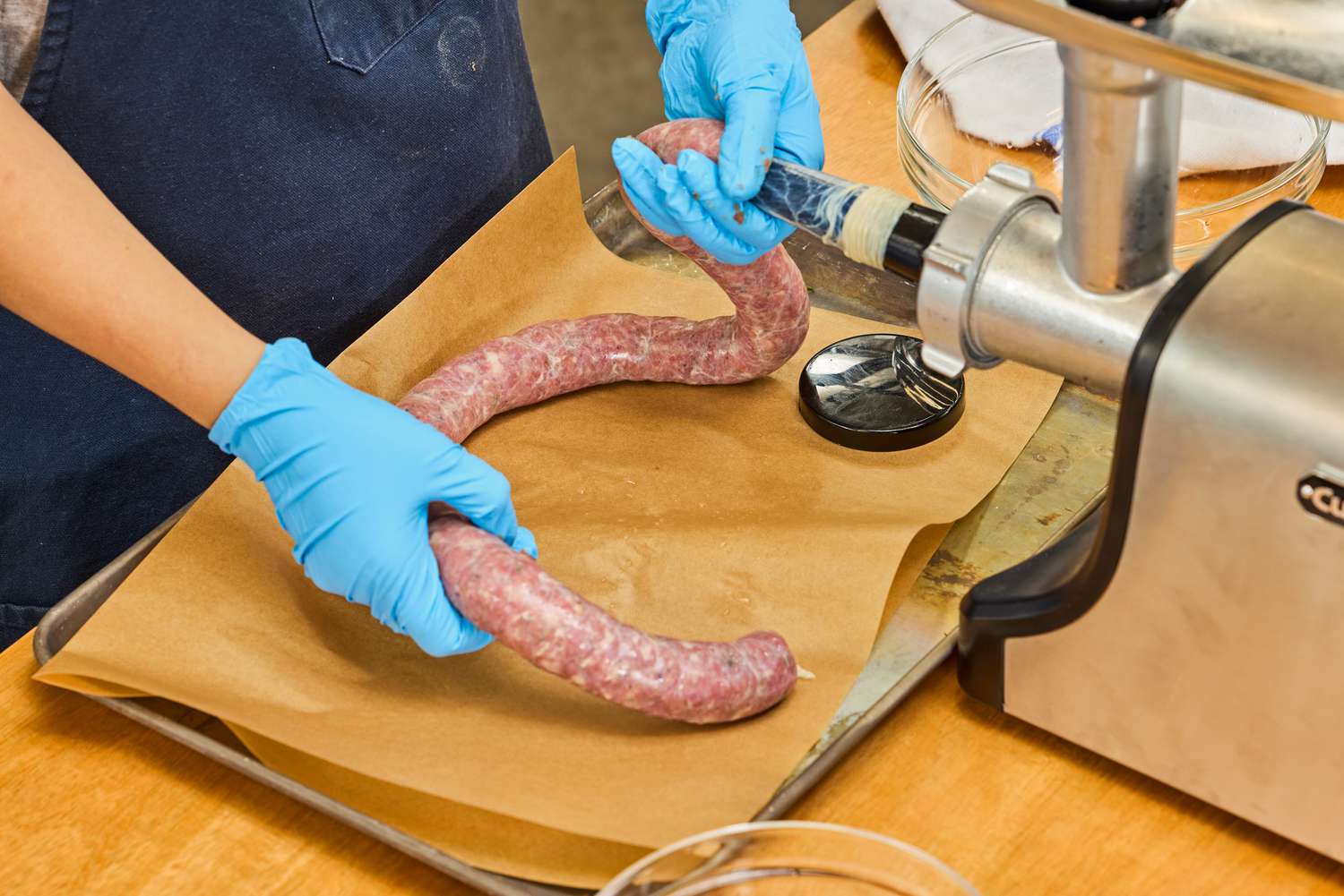 A person makes sausage using the Cuisinart Electric Meat Grinder