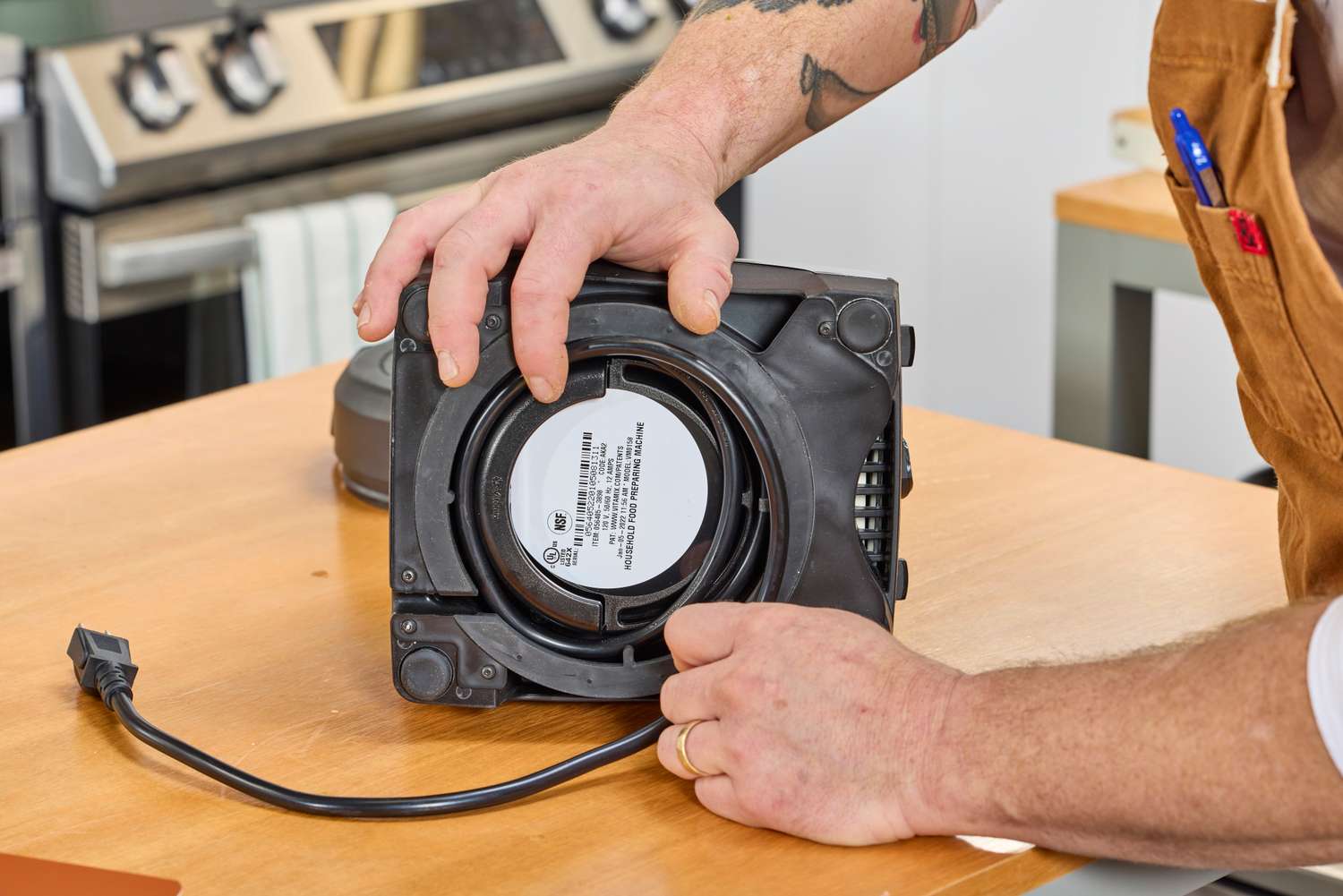 A person removing the cord from the bottom of the Vitamix 7500