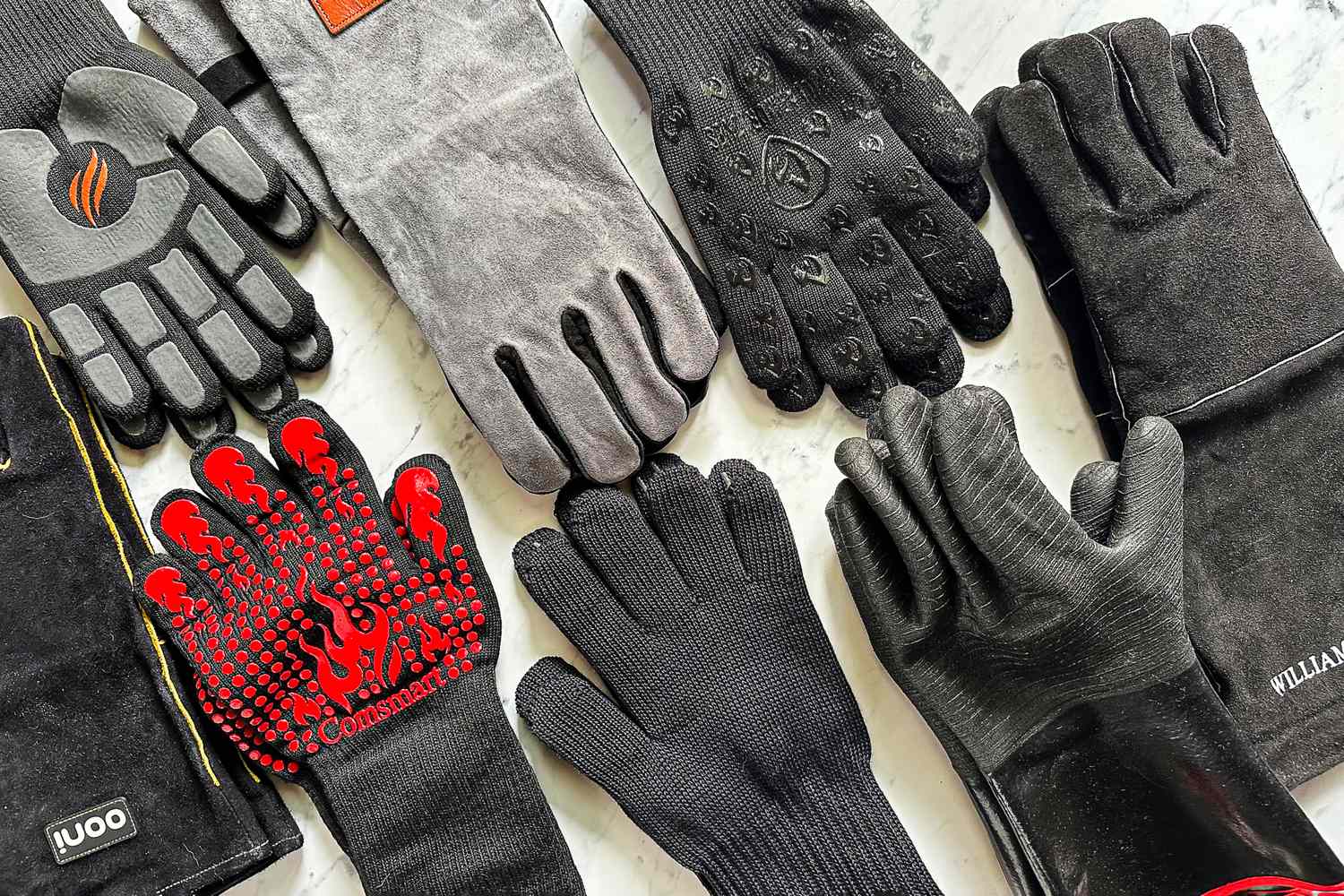 A variety of heat resistant gloves arranged on a surface showcasing different designs and materials