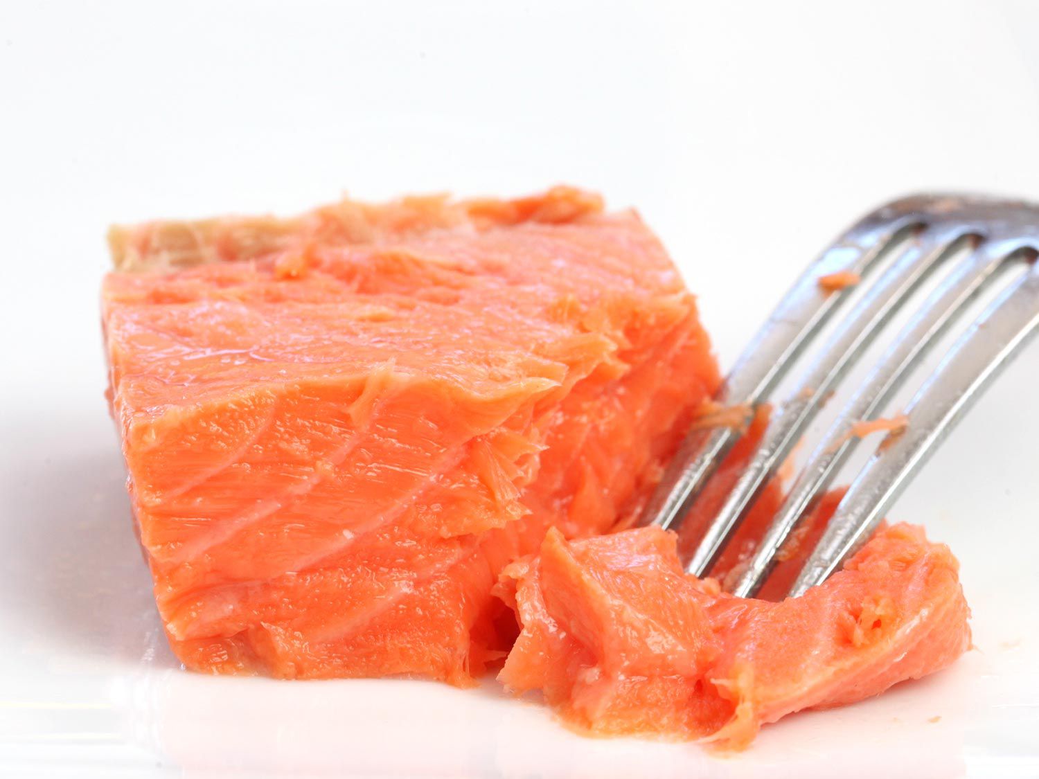 Using a fork to flake chilled salmon cooked sous vide.