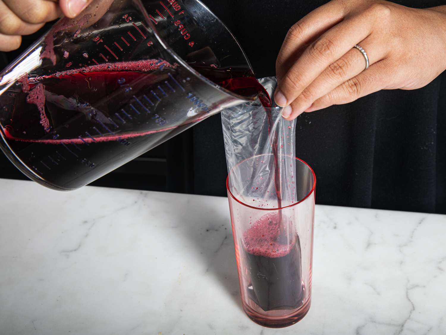 Side view of pouring the boli mixture into a boli bag supported by a glass
