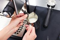 A person using the frother of the Rancilio Silvia Espresso Machine 