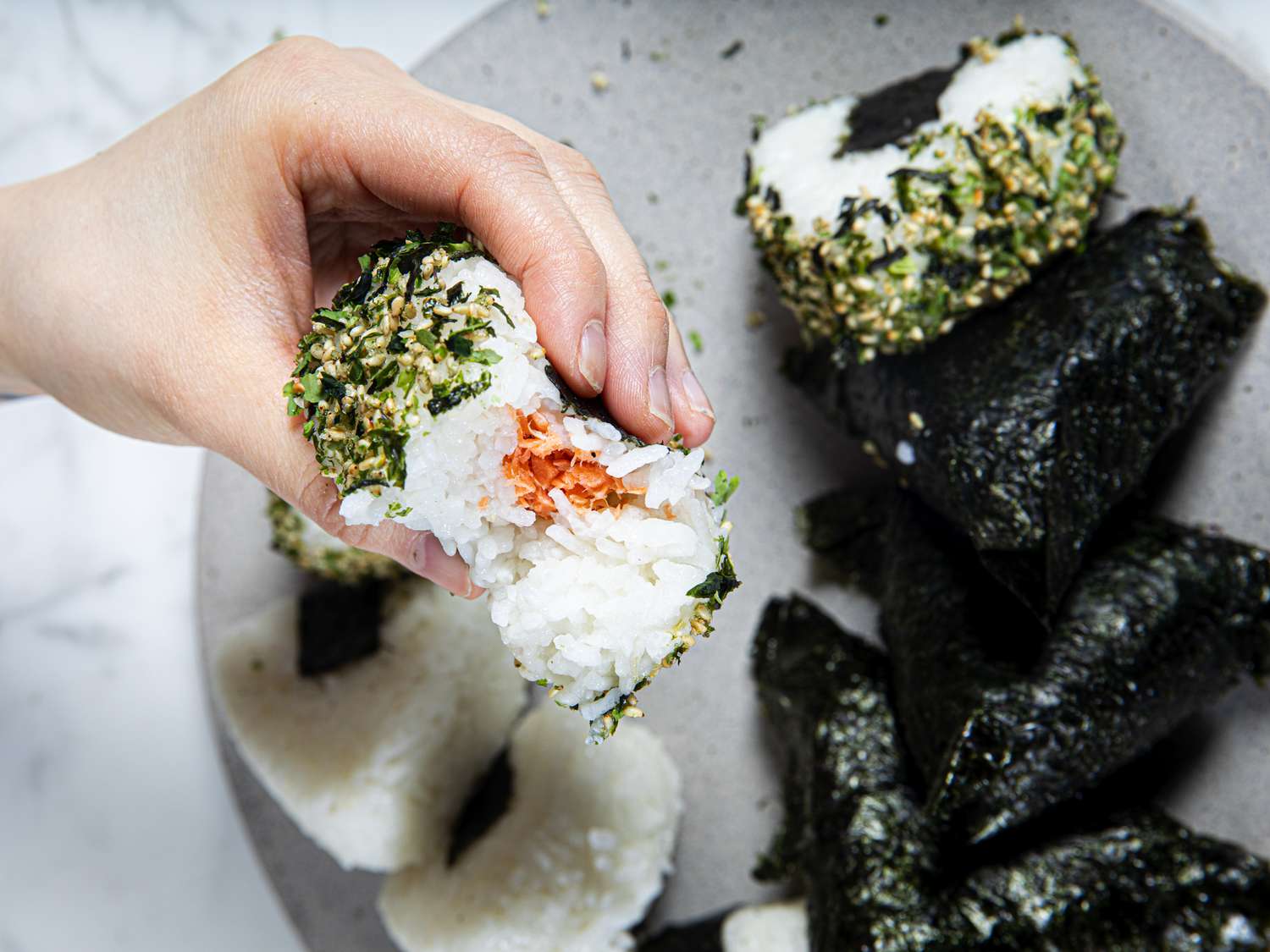 Overhead view of a hand holding onigiri
