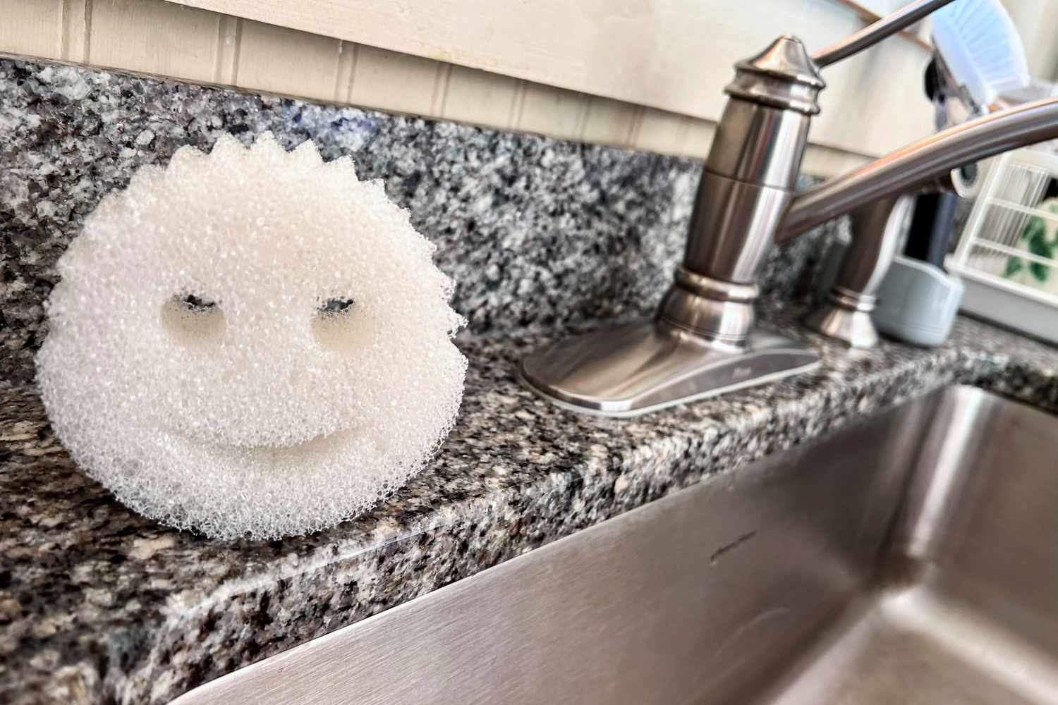 The Scrub Daddy dishwashing sponge next to a kitchen sink