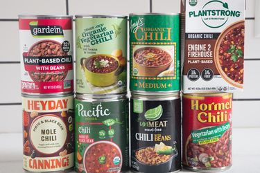 Various brands and types of canned vegetarian chili arranged in a group