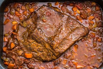 Overhead shot of a Jewish-style braised brisket in a sauce of carrots and onions