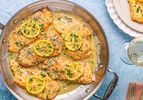 Chicken Francese served in a pan with lemon slices and sauce
