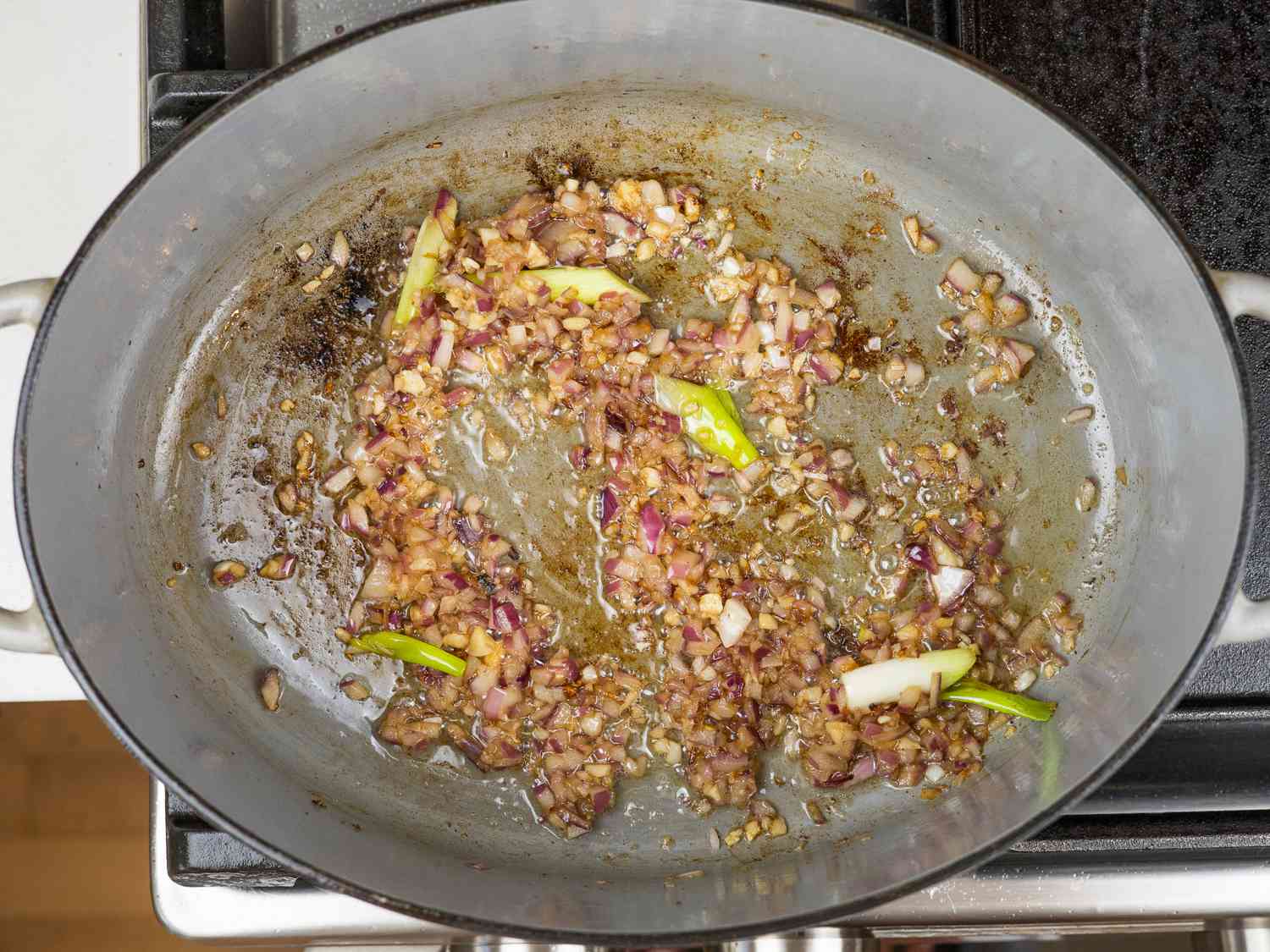 Aromatics for kare kare frying in a Dutch oven