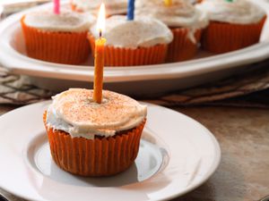 Frosted Gluten-Free Pumpkin Spice Cupcakes decorated with birthday candles