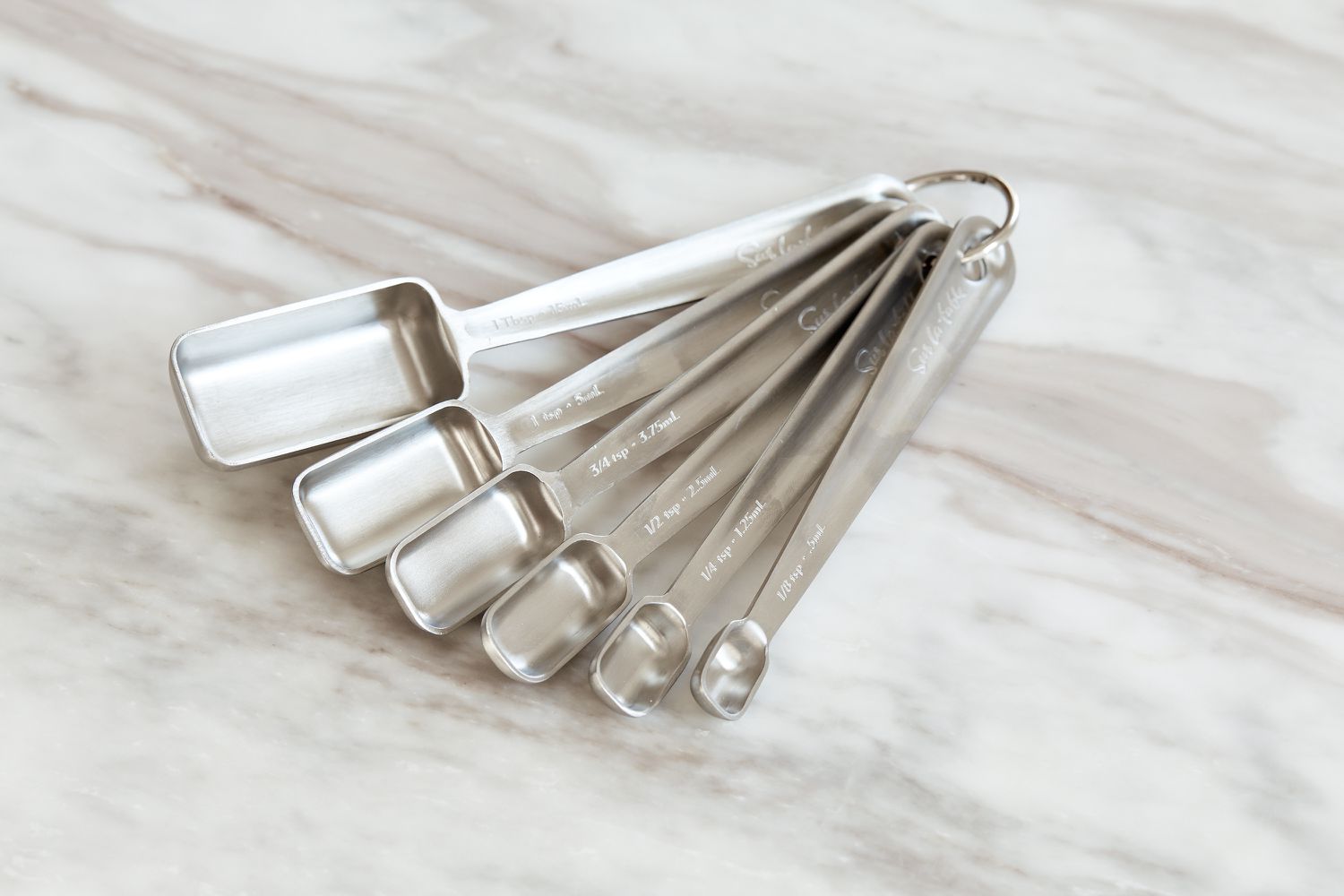 a set of rectangular measuring spoons on a marble surface