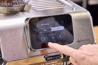A person presses a button on the De'Longhi La Specialista Touch Espresso Machine