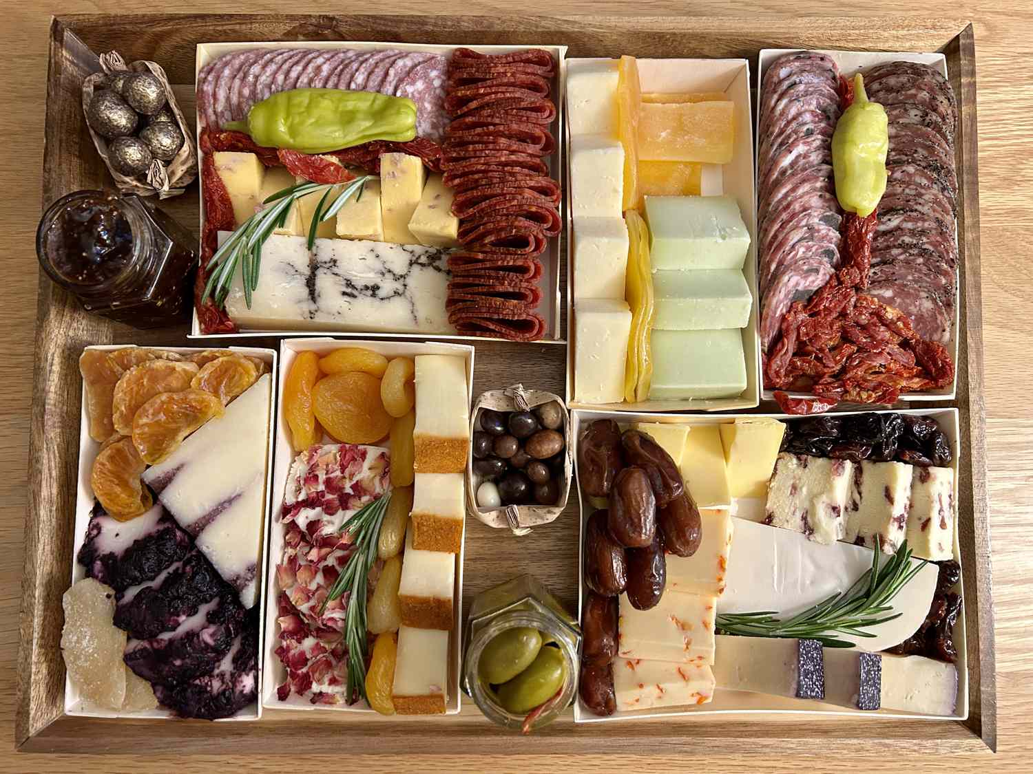 A charcuterie board containing cured meats, cheeses, olives, and fruit