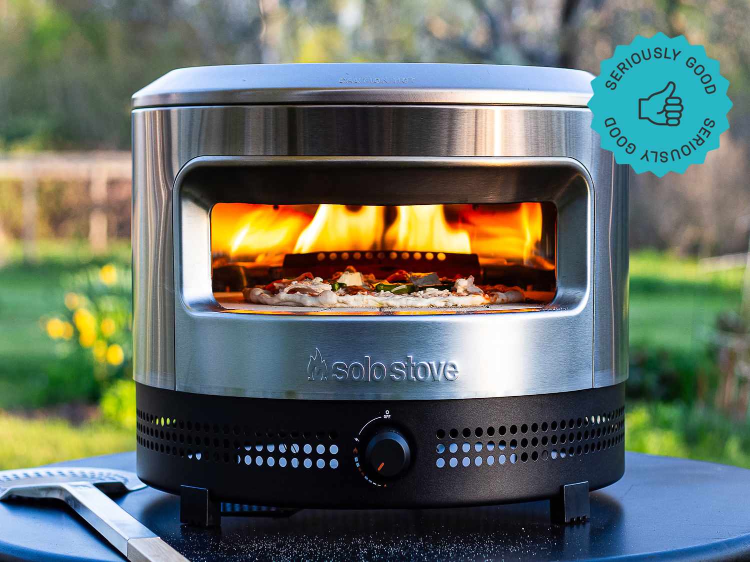 the solo stove pizza oven with a pizza baking inside