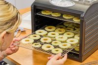 A person inserting the food tray to Samson Silent Dehydrator