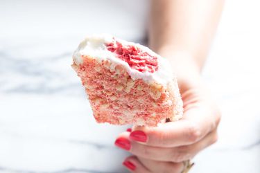 Closeup of a Strawberry Shortcake Ice Cream Bar, held upright for the camera by the author. A bite has been taken, revealing the swirled strawberry interior.