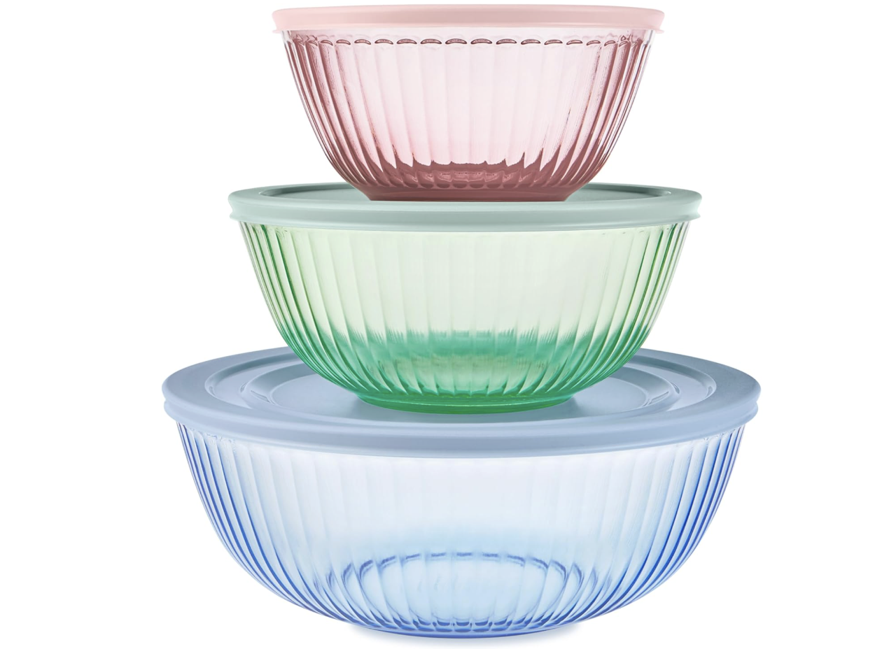 A stack of three ribbed bowls with lids one pink one green one blue