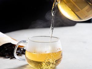 Tea going into a glass cup.
