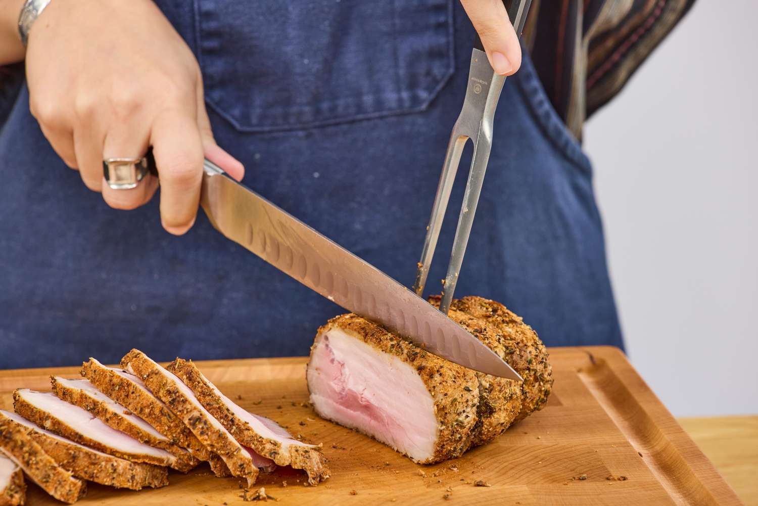 A person cuts meat with the Wüsthof Classic Carving Set