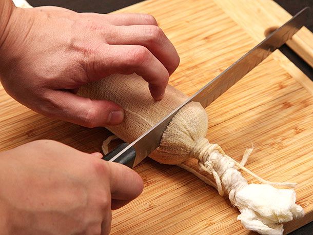 Trimming the end of foie gras torchon. 