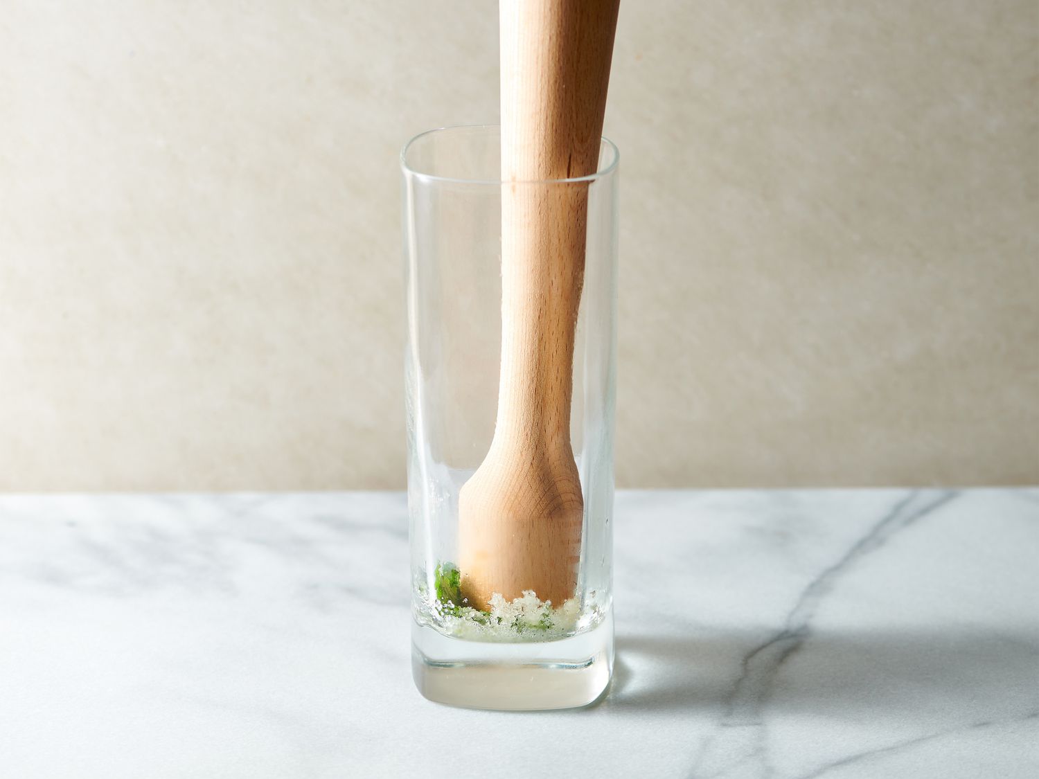 Sugar and mint leaves gently muddled in a serving glass