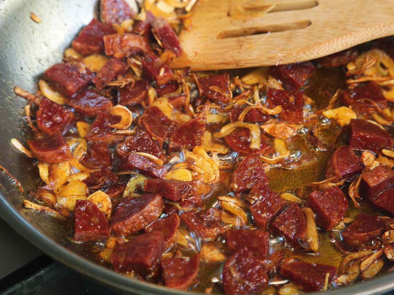 The chorizo, shallots, and garlic are slowly cooked in olive oil.